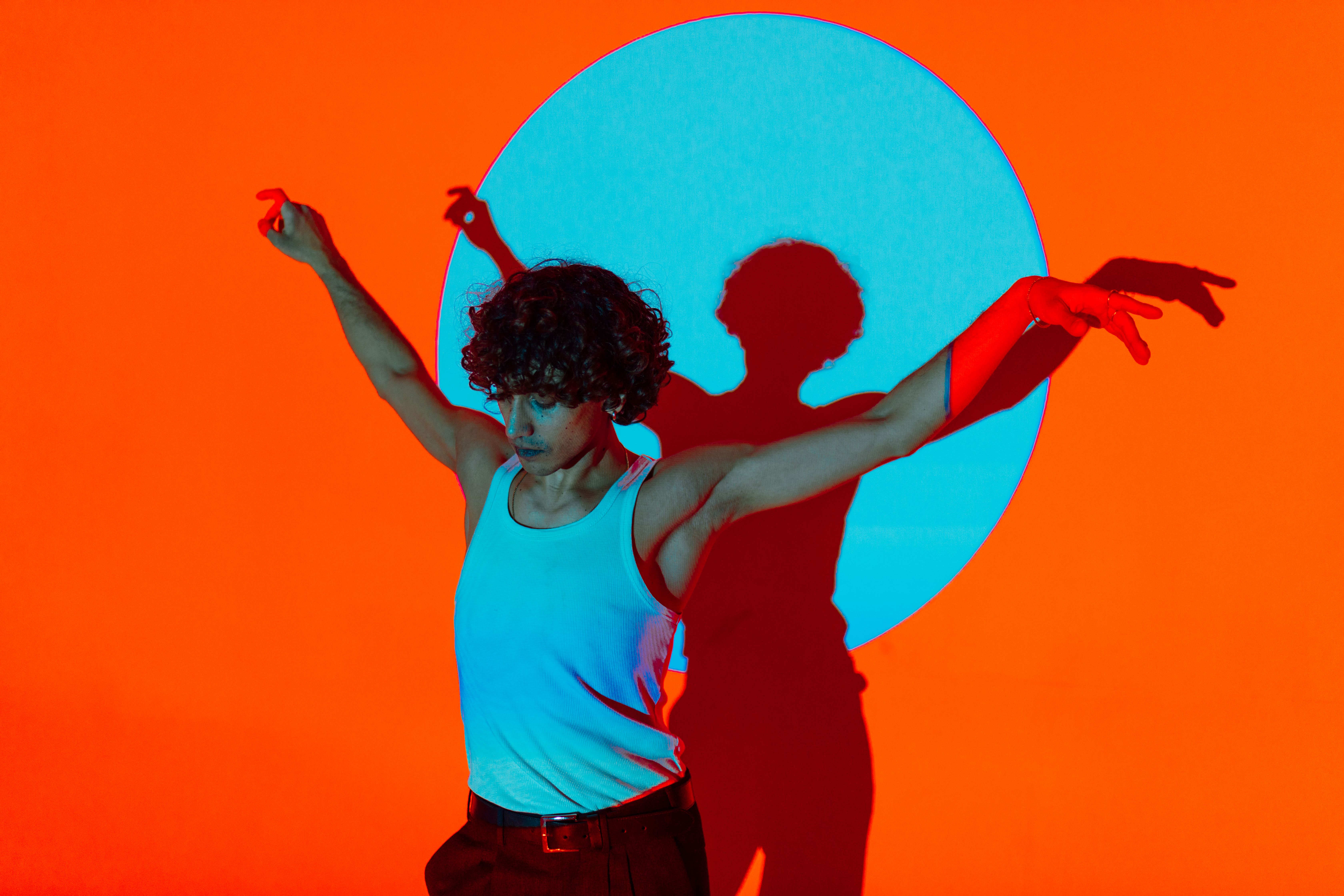 A male dancer performing artful ballet moves against a vibrant backdrop.