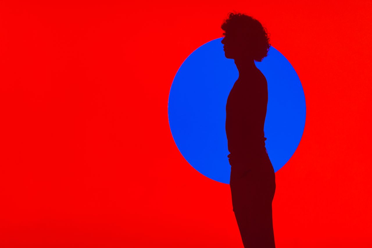 artistic silhouette of a ballet dancer against a bold red and blue bac