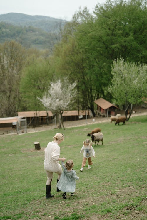 Free Mother and Daughters Walking on the Grass Stock Photo