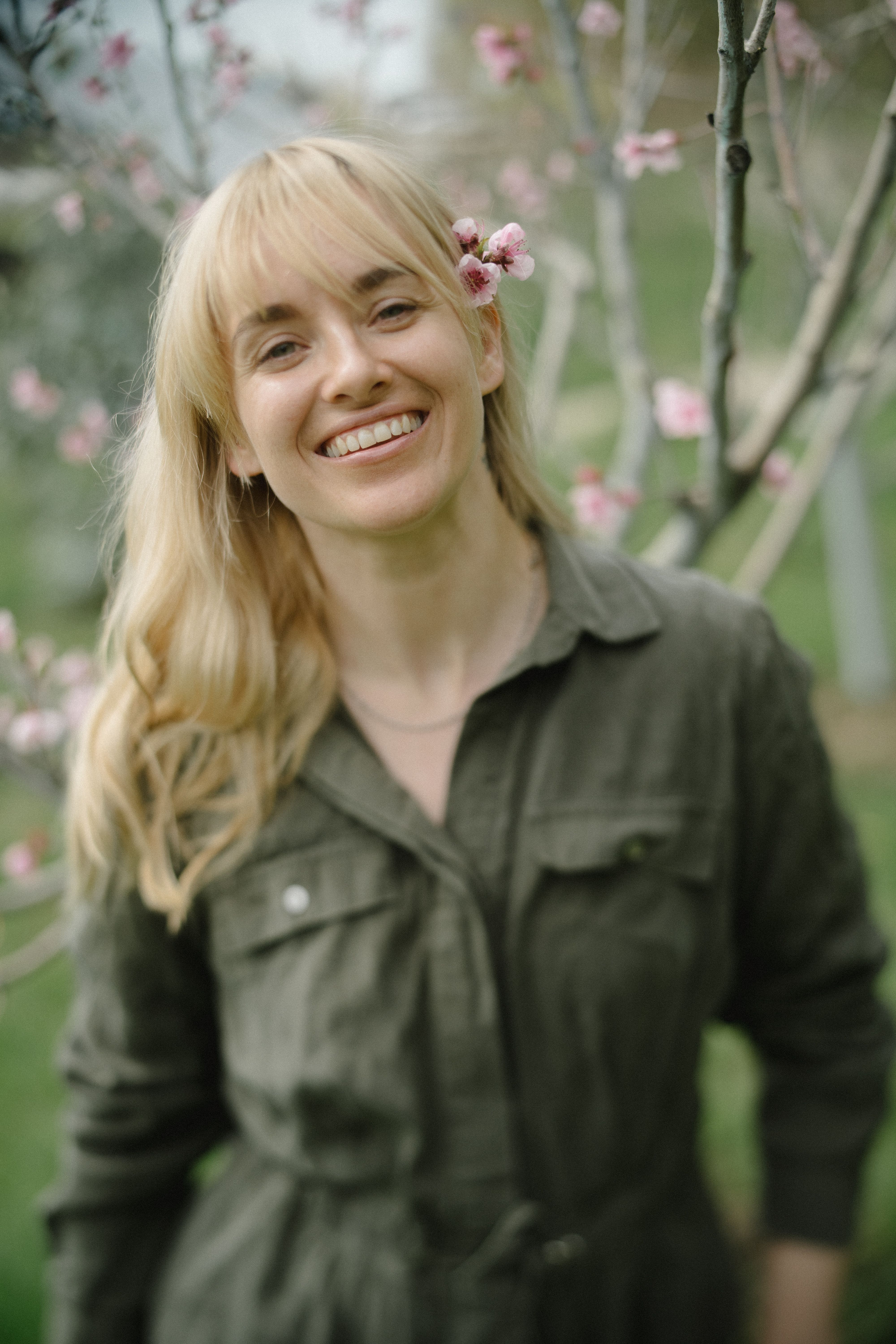 Woman in Green Jacket Standing Near a Tree · Free Stock Photo