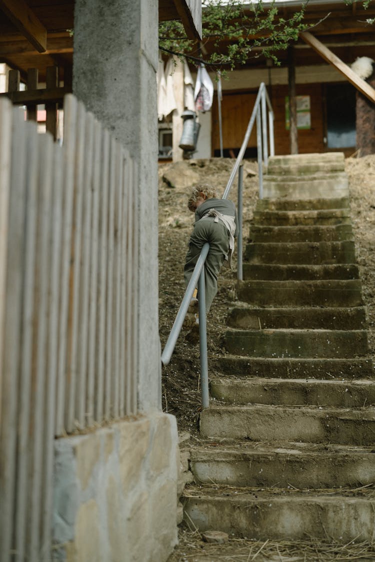 A Kid Sliding Down On A Handrail 