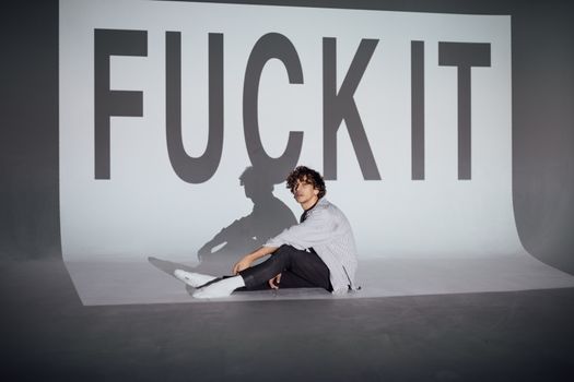 Man in Gray Long Sleeve Shirt and Black Pants Sitting on Floor