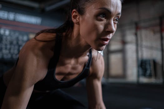 Close-up of a determined female athlete sweating during a workout session indoors.