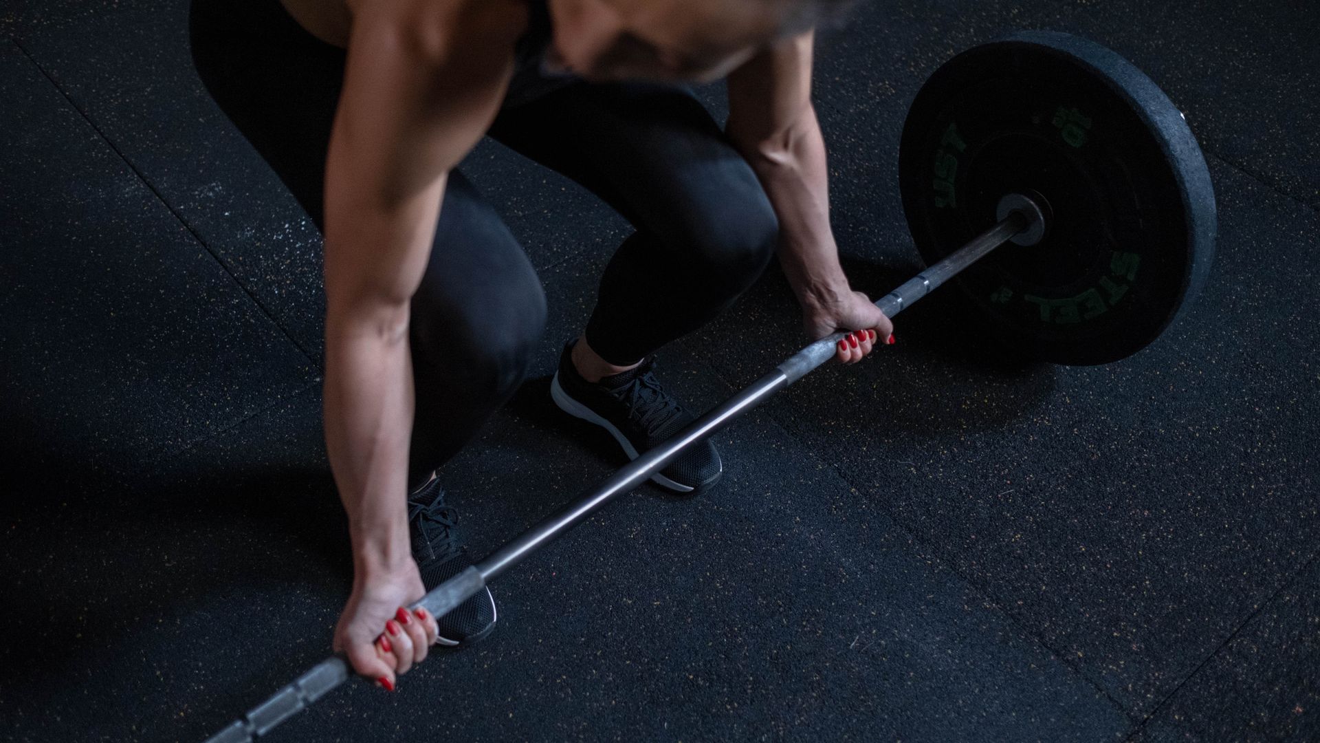 Modafinil and Exercise: Unlocking Physical Potential Woman lifting barbell in gym, showcasing strength and fitness. Great for active lifestyle themes — modafinil and exercise