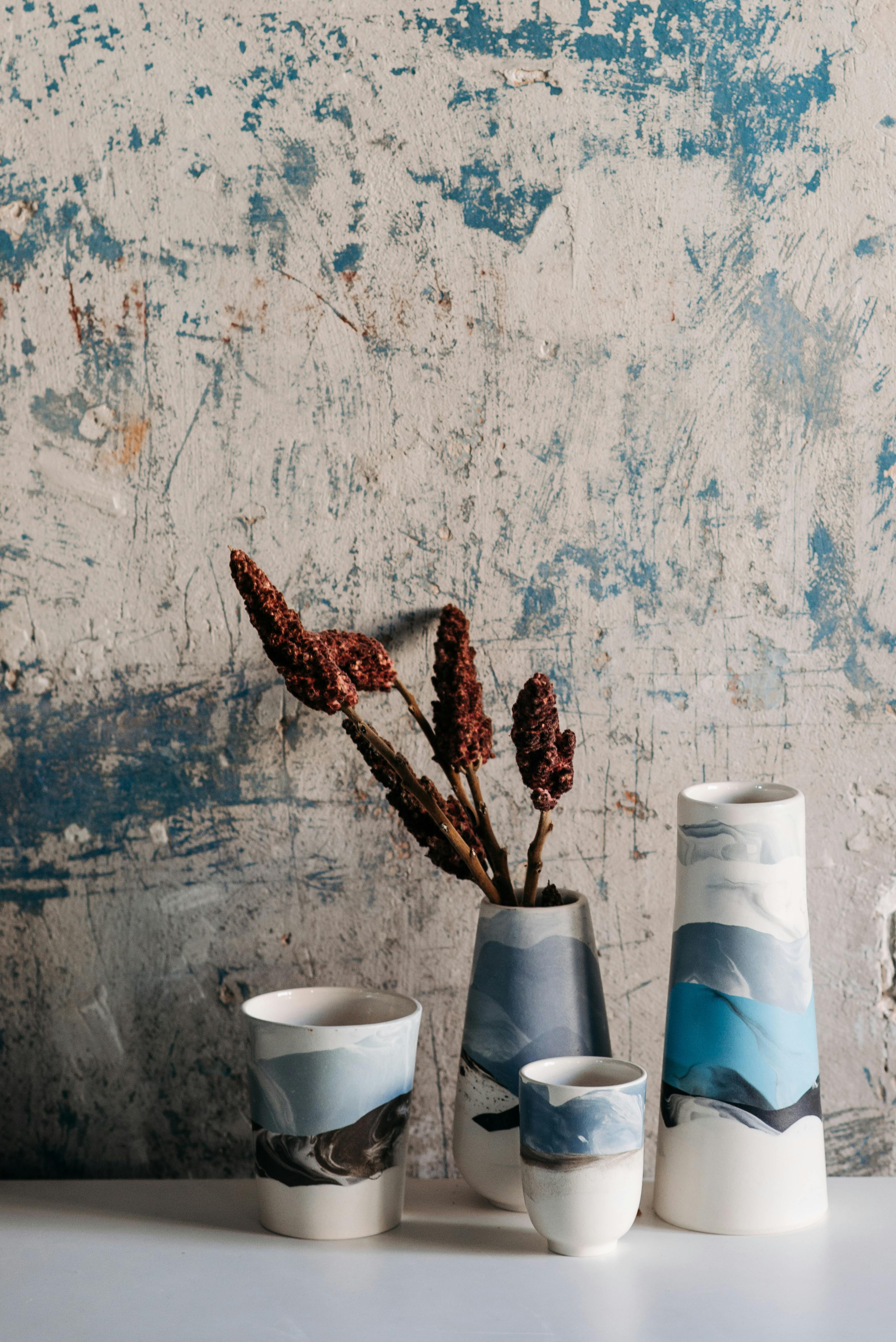 White and Blue Ceramic Vases Near the Dirty Wall · Free Stock Photo