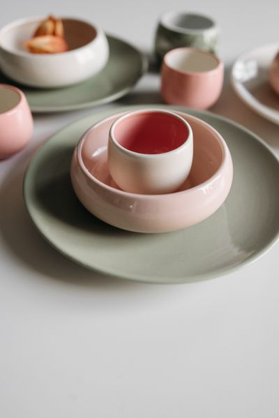 Glazed egg cup on stacked ceramic plates — photo by Pavel Danilyuk on Pexels