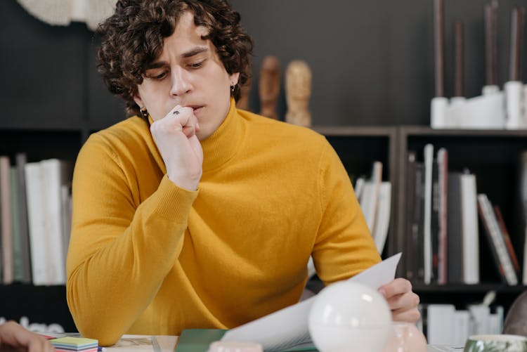 Man In Yellow Sweater Biting His Finger 