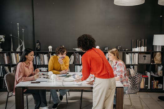 A diverse team engaged in a brainstorming session at a modern office table with documents and ceramics.