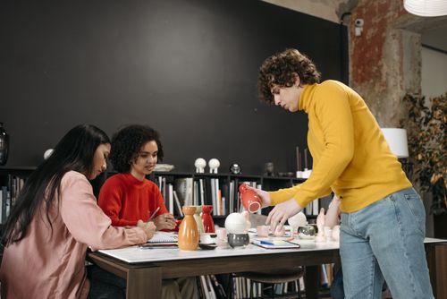 Free A diverse group of adults working together on a ceramics project in a modern office setting. Stock Photo
