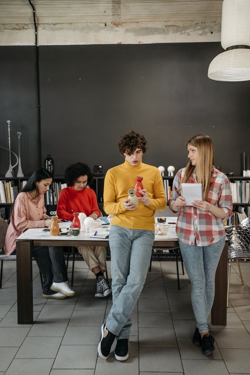 Free A diverse group of coworkers collaborate indoors on a ceramics project, showcasing teamwork and creativity. Stock Photo