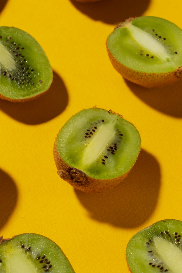 Close-Up Photo Of Kiwis On Yellow Surface