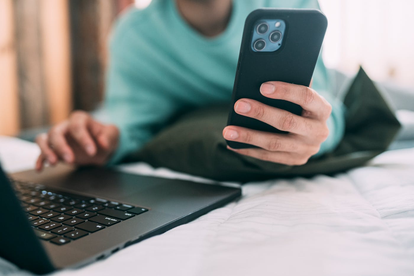 Persona con laptop e smartphone che mostra conferma di accesso a due fattori
