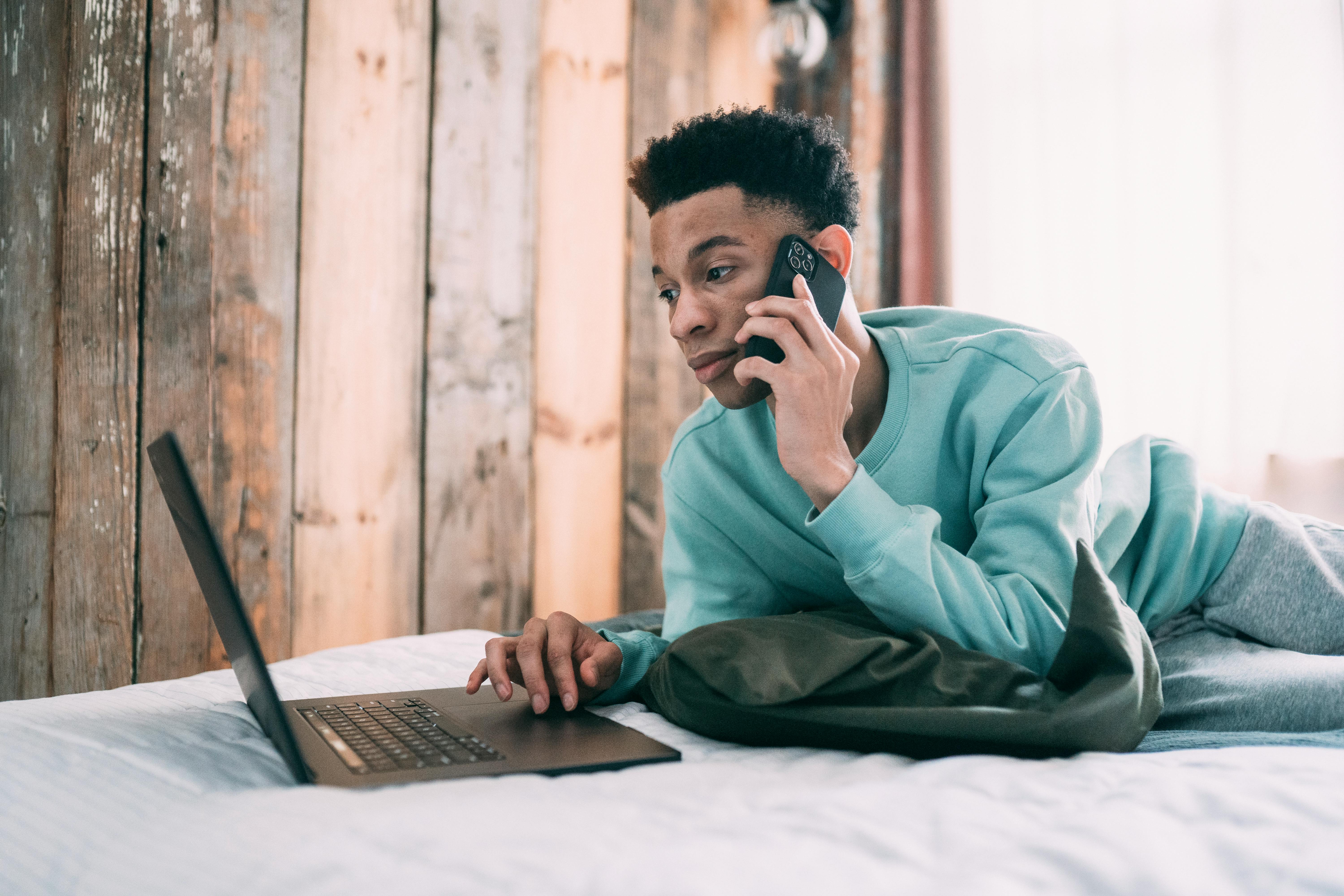 thoughtful black man having phone call in bedroom