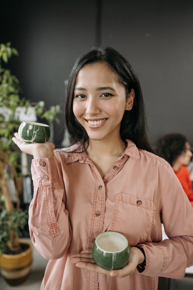 A Woman Holding A Ceramic Cups