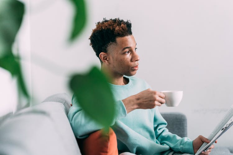 Black Man With Magazine Drinking Coffee