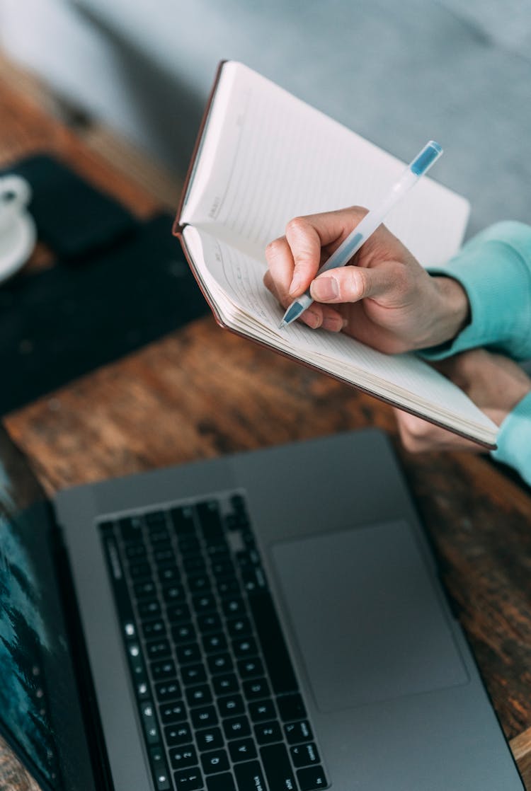 Crop Person Taking Notes While Working