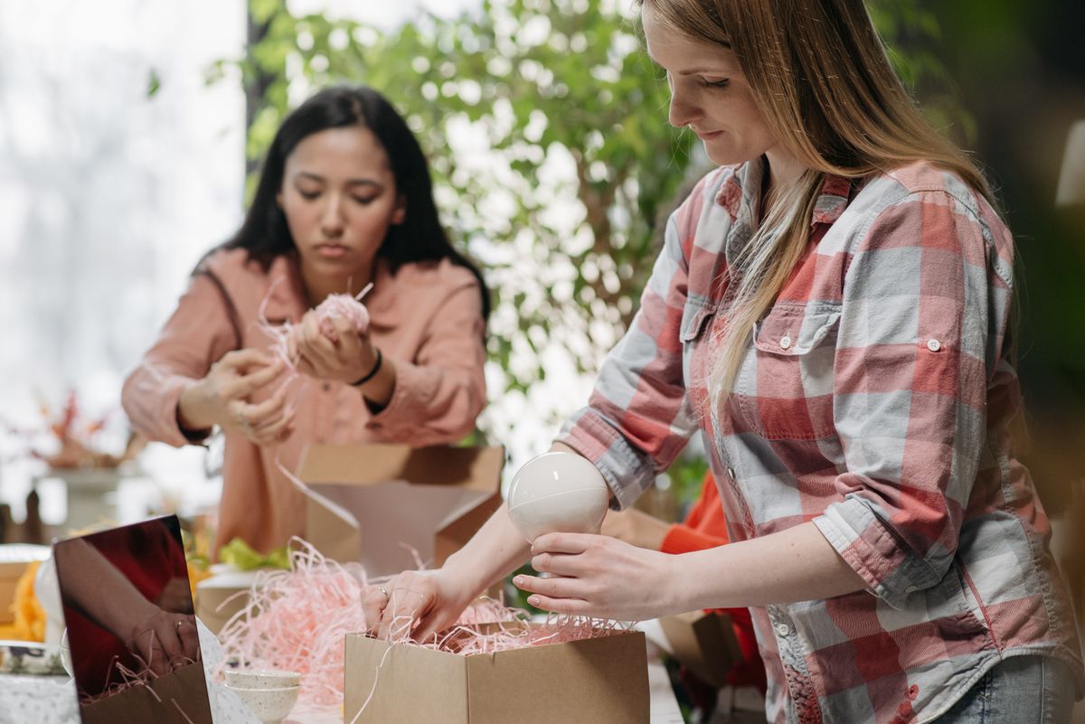 Fulfillment workers packing orders into cardboard boxes