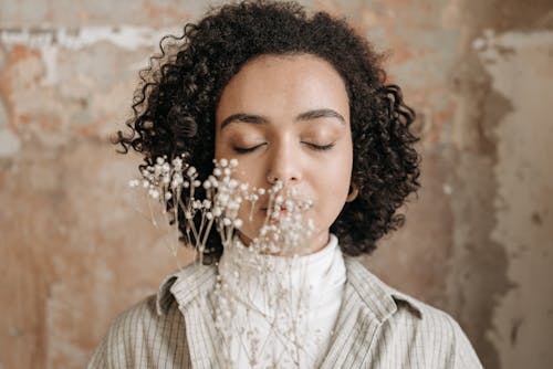 Free Flowers in Front of a Woman with Curly Hair Stock Photo