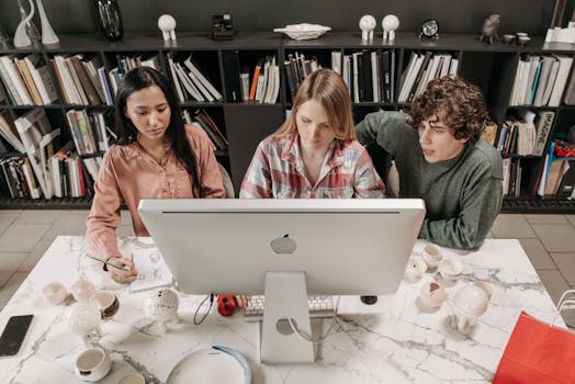 Three colleagues collaborating on a project in a modern office setting.
