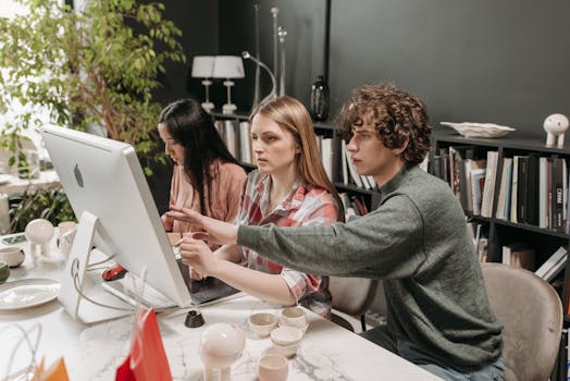 Three colleagues collaborating at a computer in a stylish office space.