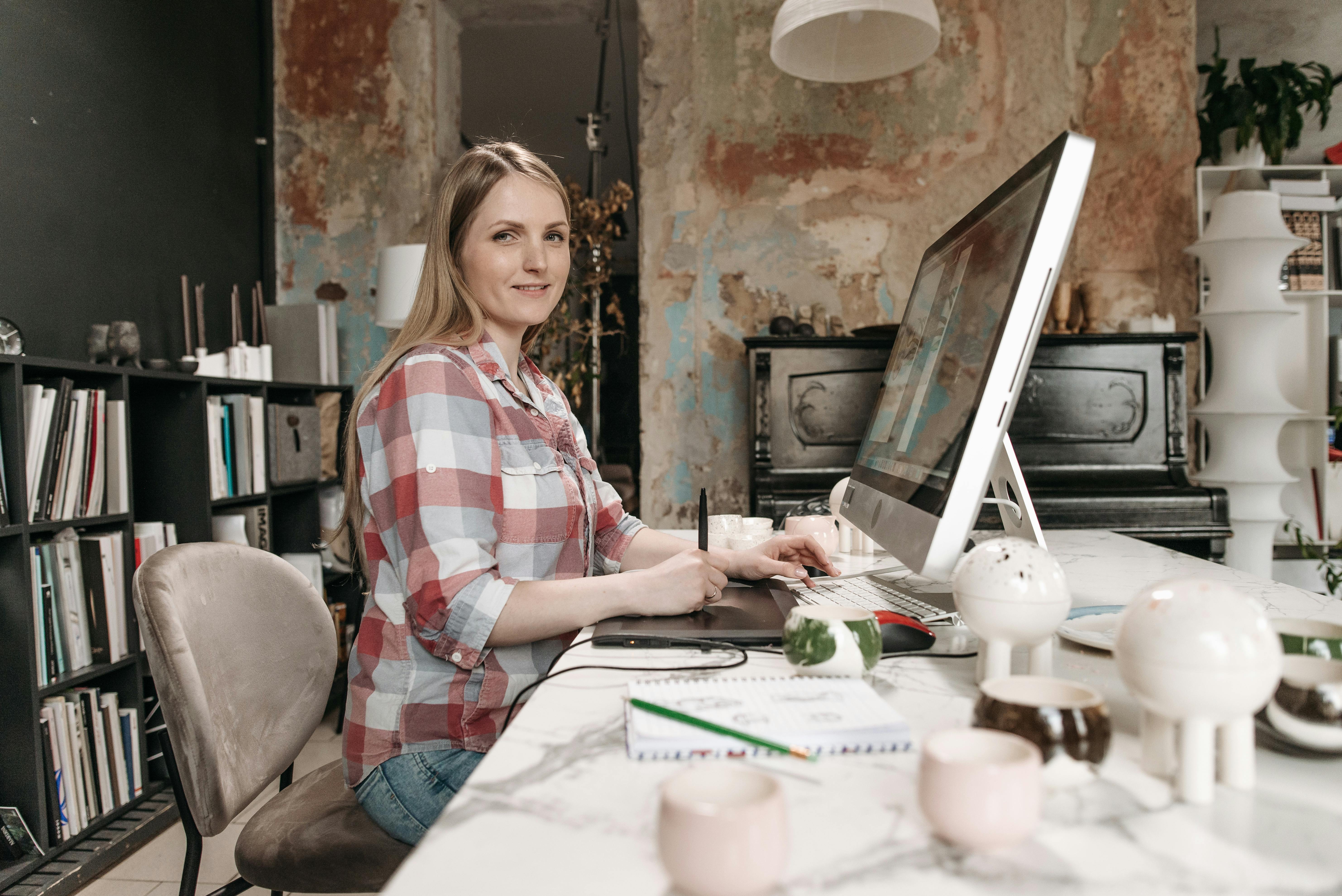 woman in plaid shirt sitting working in an office
