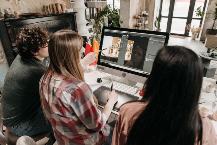 Three people reviewing a design on screen — Pavel Danilyuk on Pexels