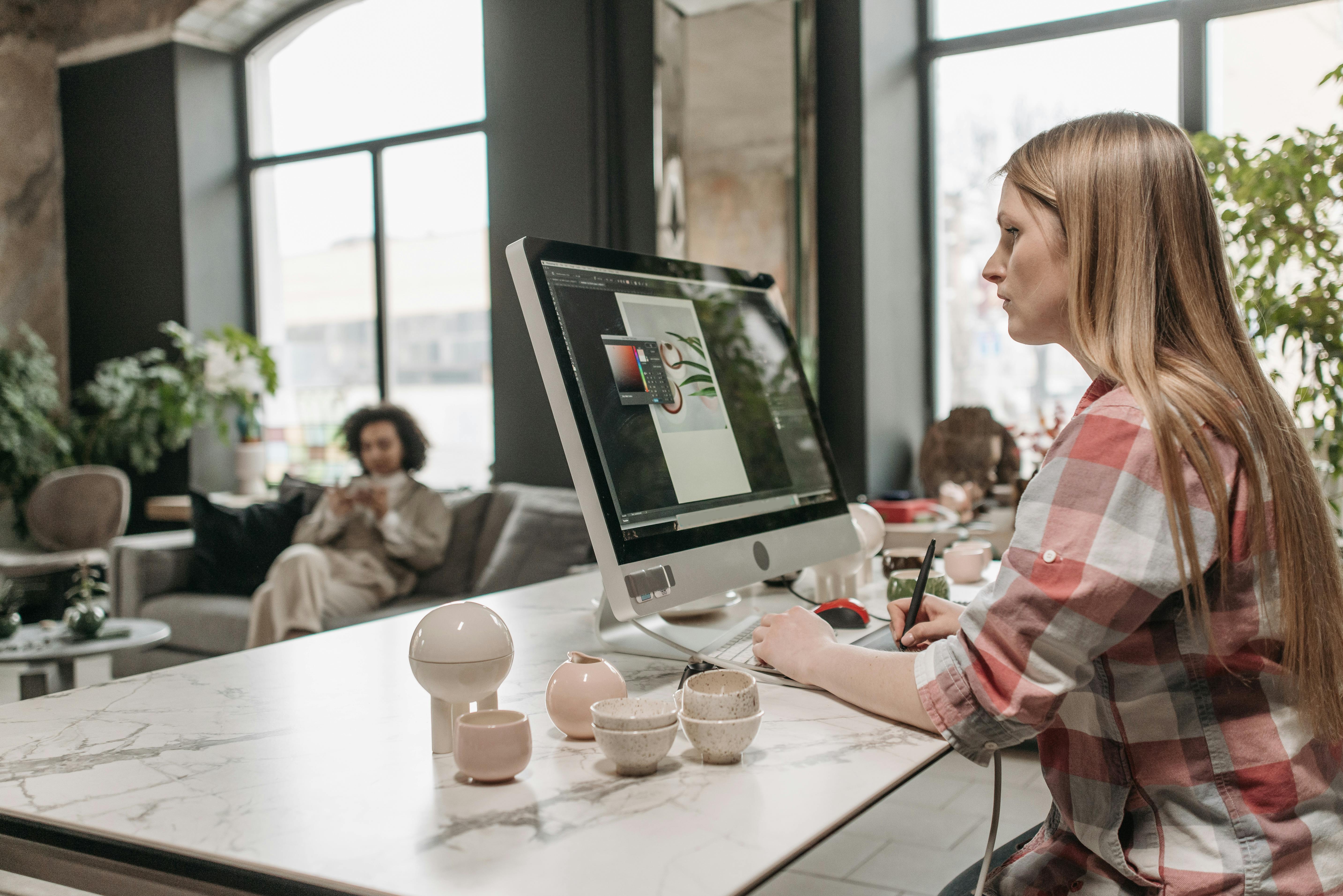 a woman in plaid shirt working on a computer