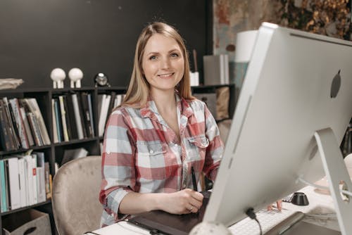 Free Blond Woman Sitting in Front of a Computer Stock Photo