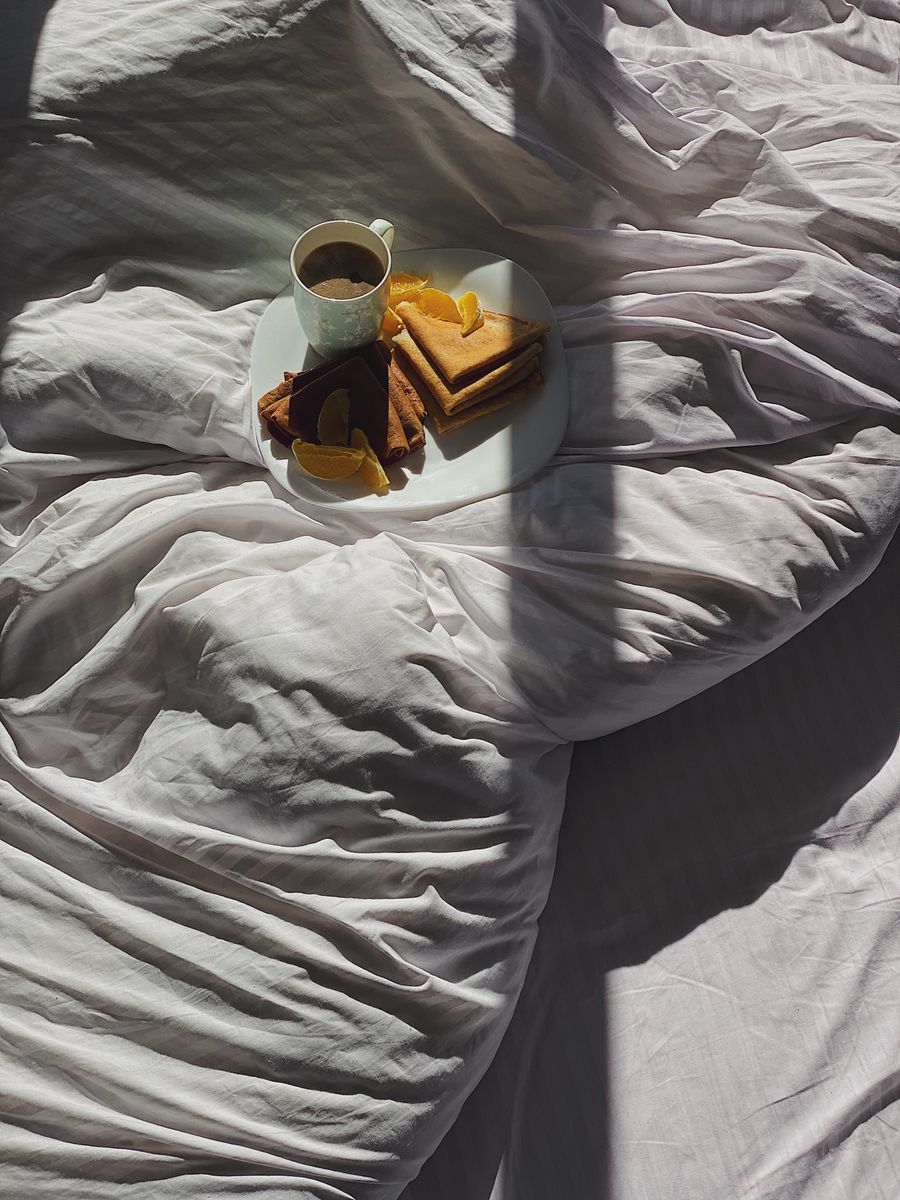 Breakfast in a sunlit unmade bed