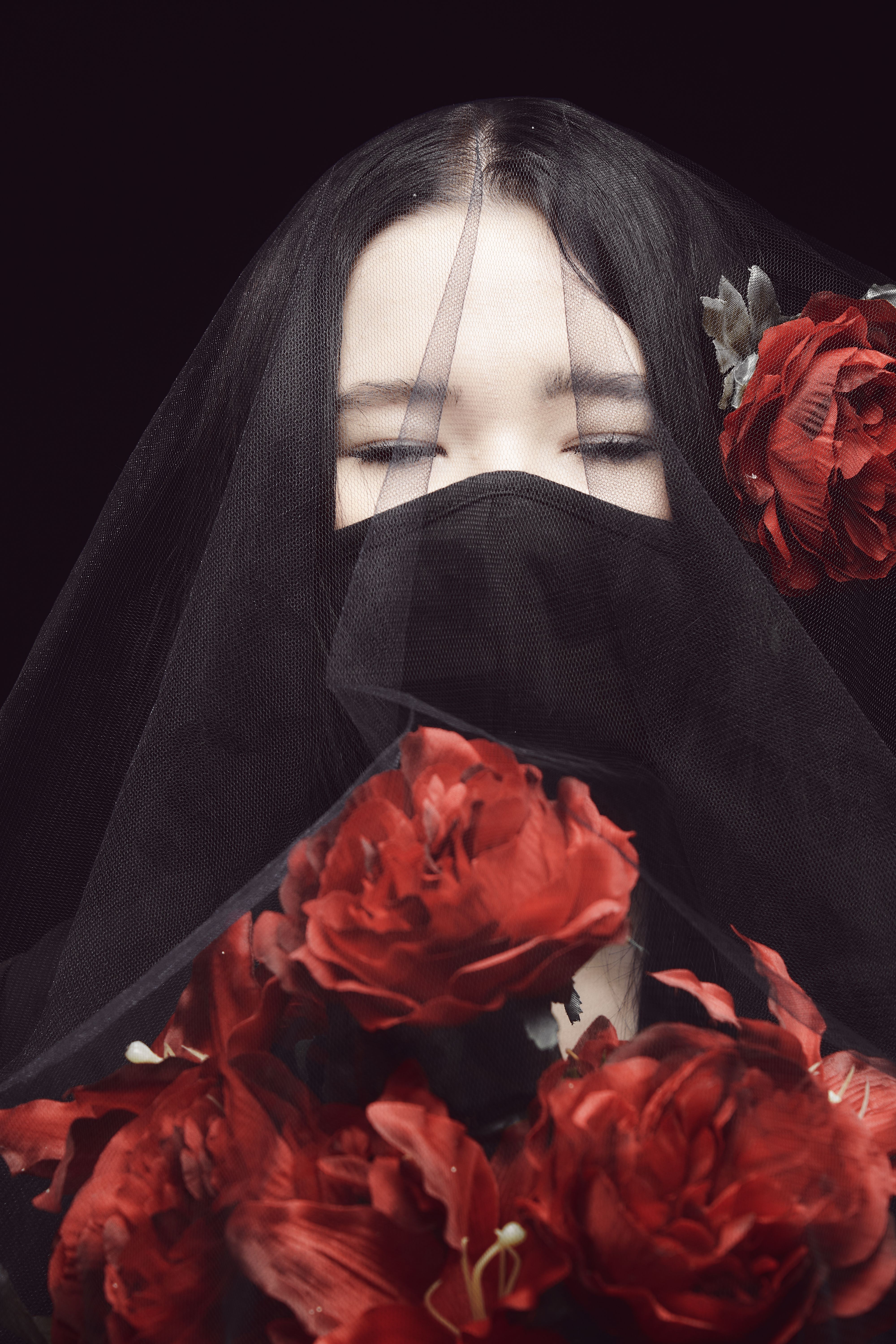 A Woman Closing Her Eyes in Black Veil Holding Red Flowers · Free Stock ...