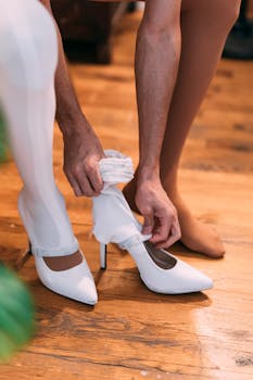 Crop anonymous female in nylon tights putting on white stockings and high heeled shoes