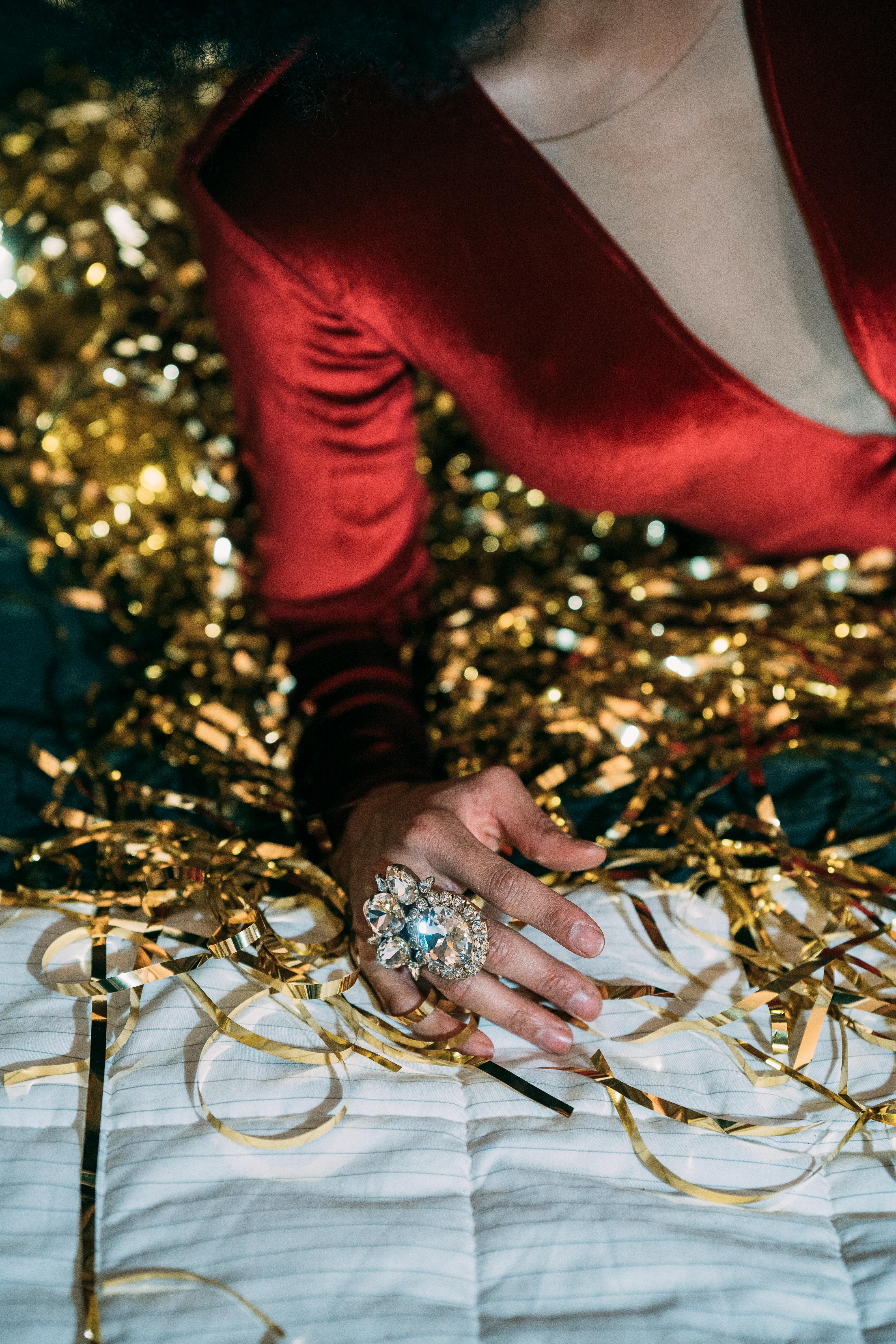 crop woman in red clothes lying on bed