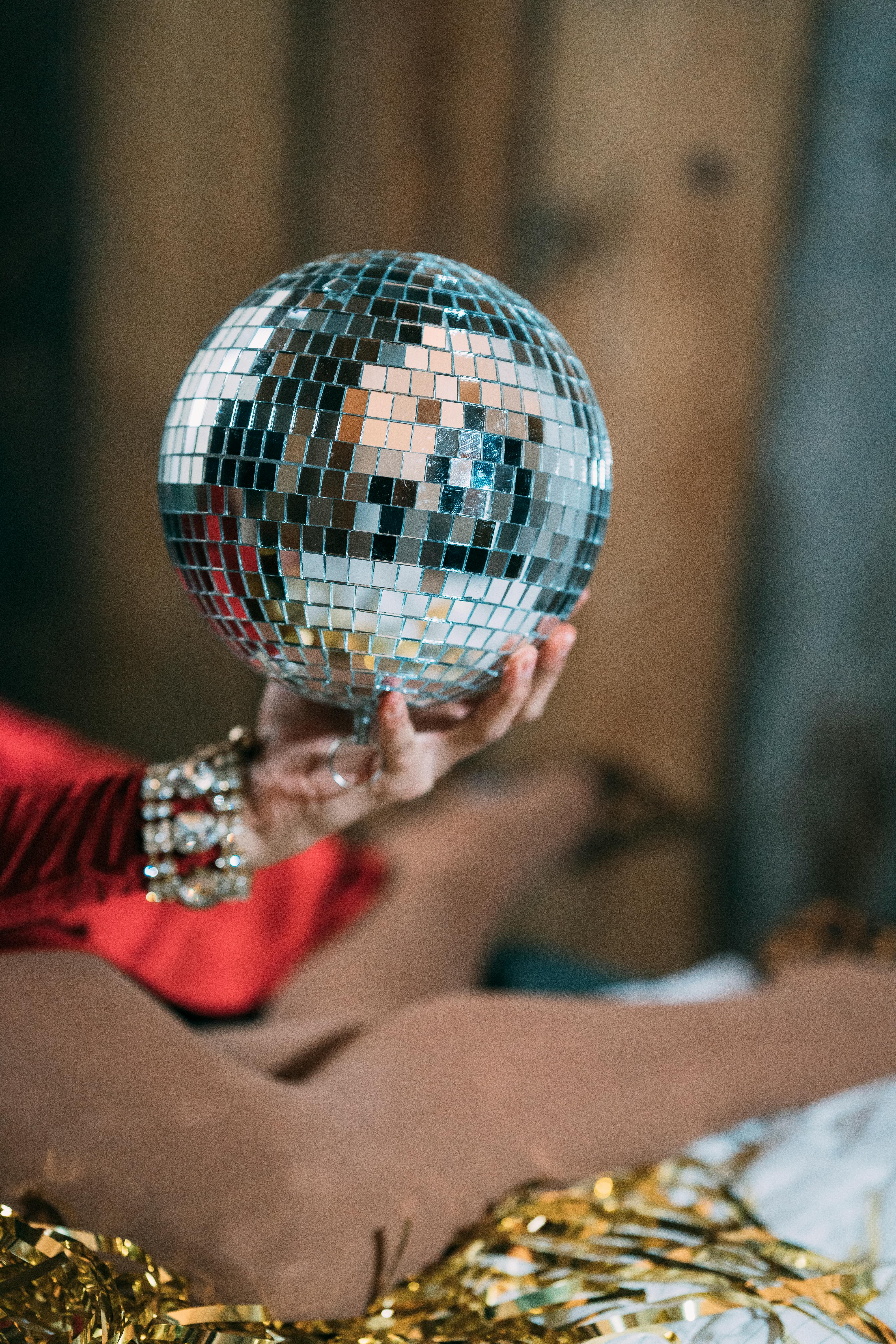 crop woman holding disco ball