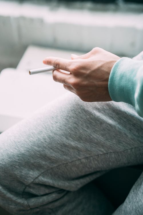 Faceless ethnic guy with cigarette