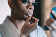 Black man applying makeup on face