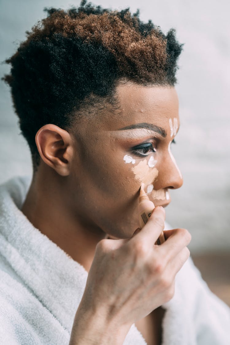 Black Man Covering Face With Cosmetic Foundation Cream