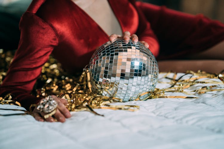 Crop Man In Drag Queen Dress Lying With Disco Ball