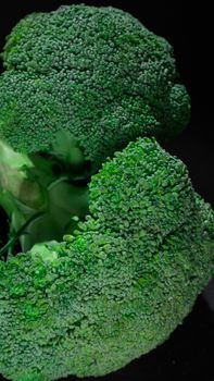 Vertical shot of vibrant green broccoli florets showcasing natural texture and pattern.