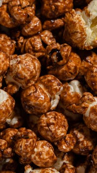 Delicious caramel popcorn close-up showcasing rich, crunchy texture under warm lighting.