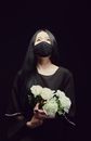 A Woman in Black Top Holding a Bouquet of White Flowers