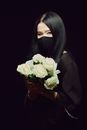 A Woman in Black Top Holding a Bouquet of White Flowers