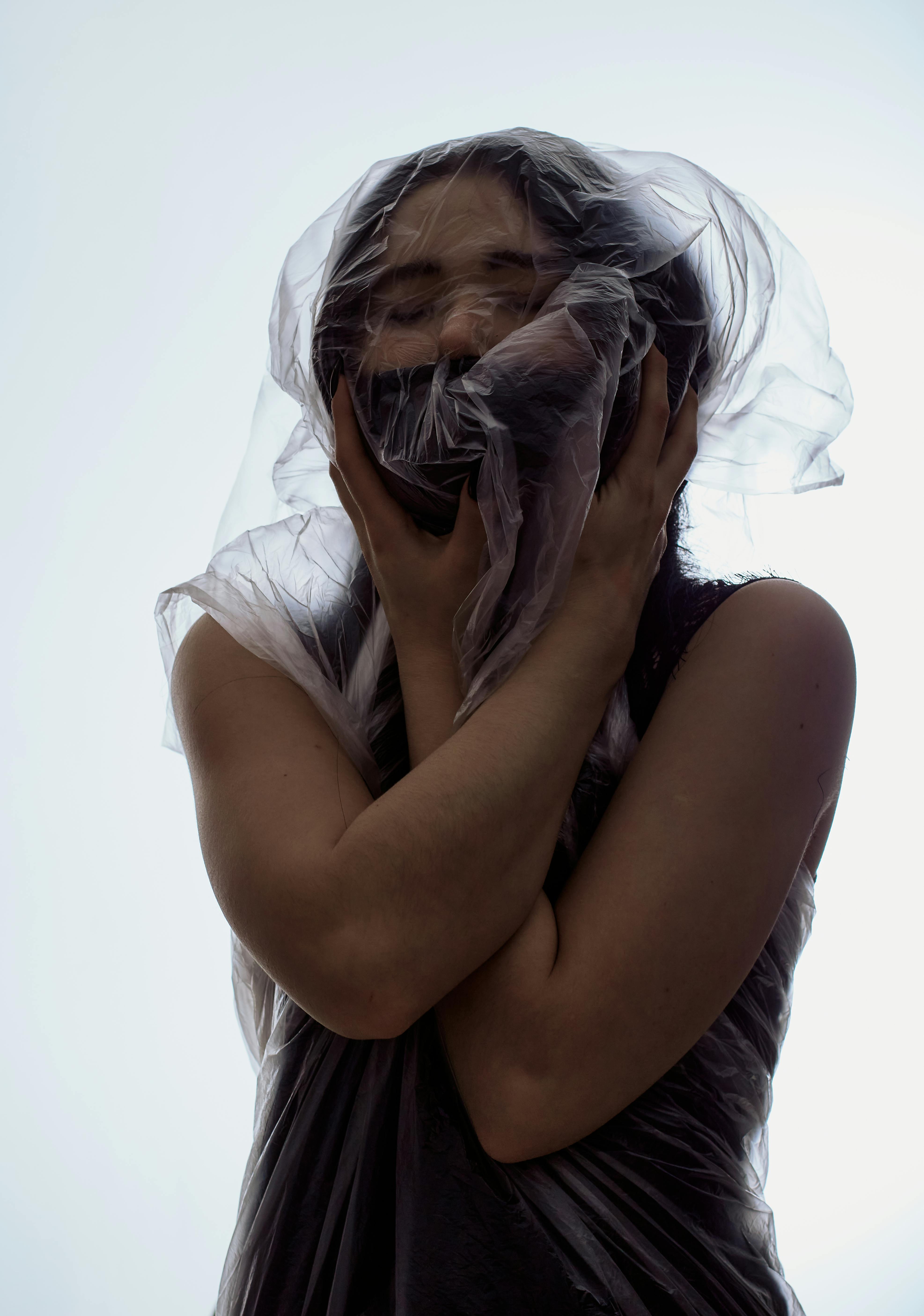 a woman wearing face mask wrapped in plastic