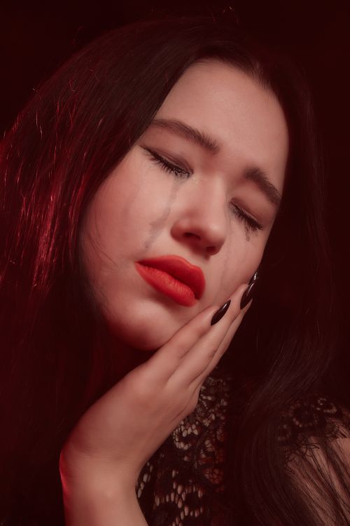 Free Close-up of a woman expressing deep sadness and tears on her cheek. Stock Photo