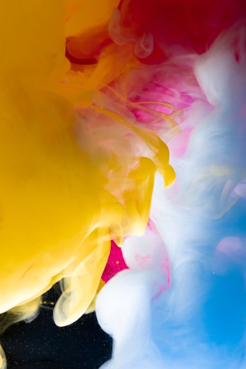 Free Vibrant abstract art with swirling smoke in yellow, pink, and blue tones. Stock Photo