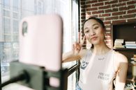 A Woman Smiling on the Camera of a Cellphone