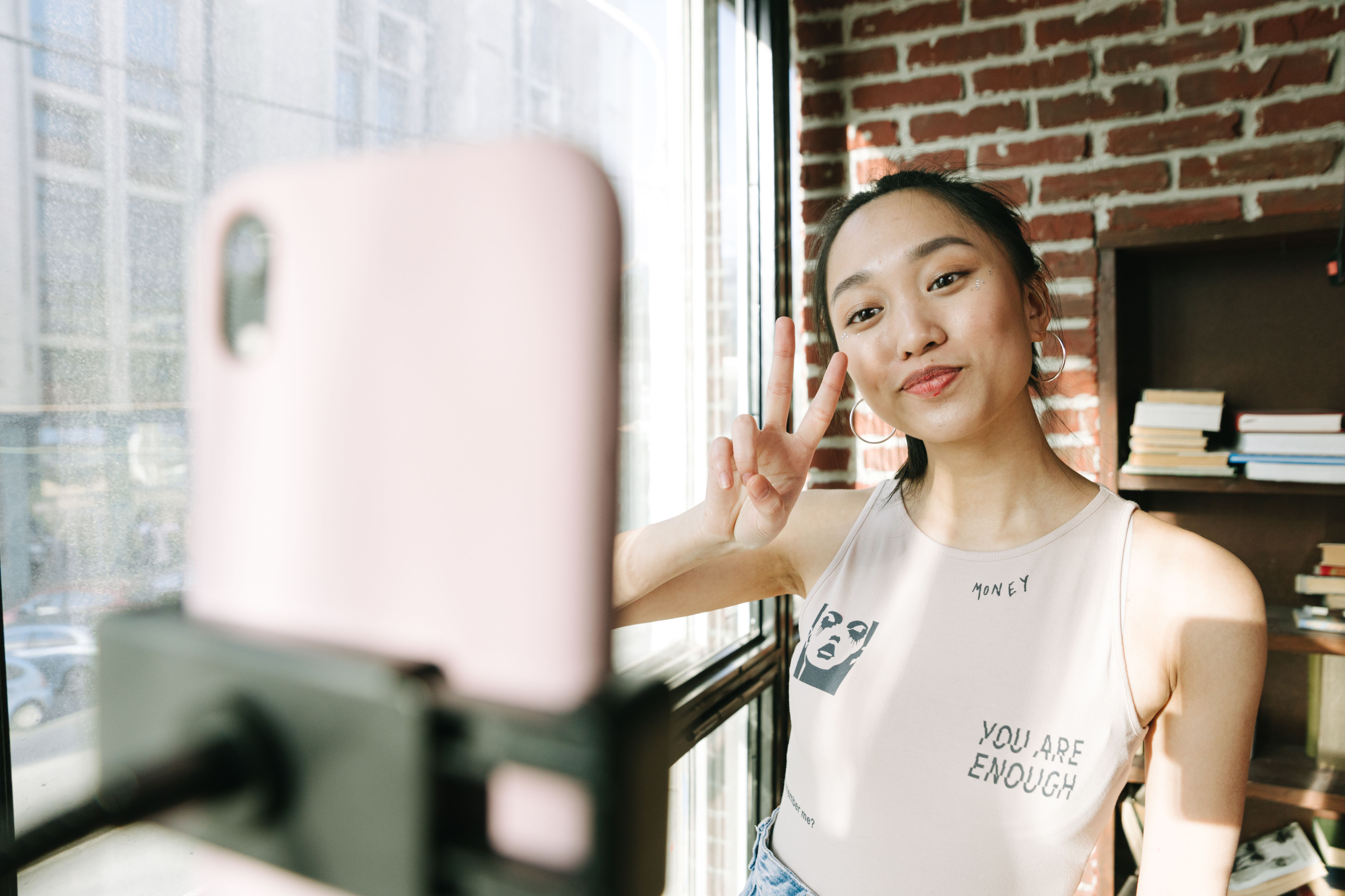A Woman Smiling on the Camera of a Cellphone