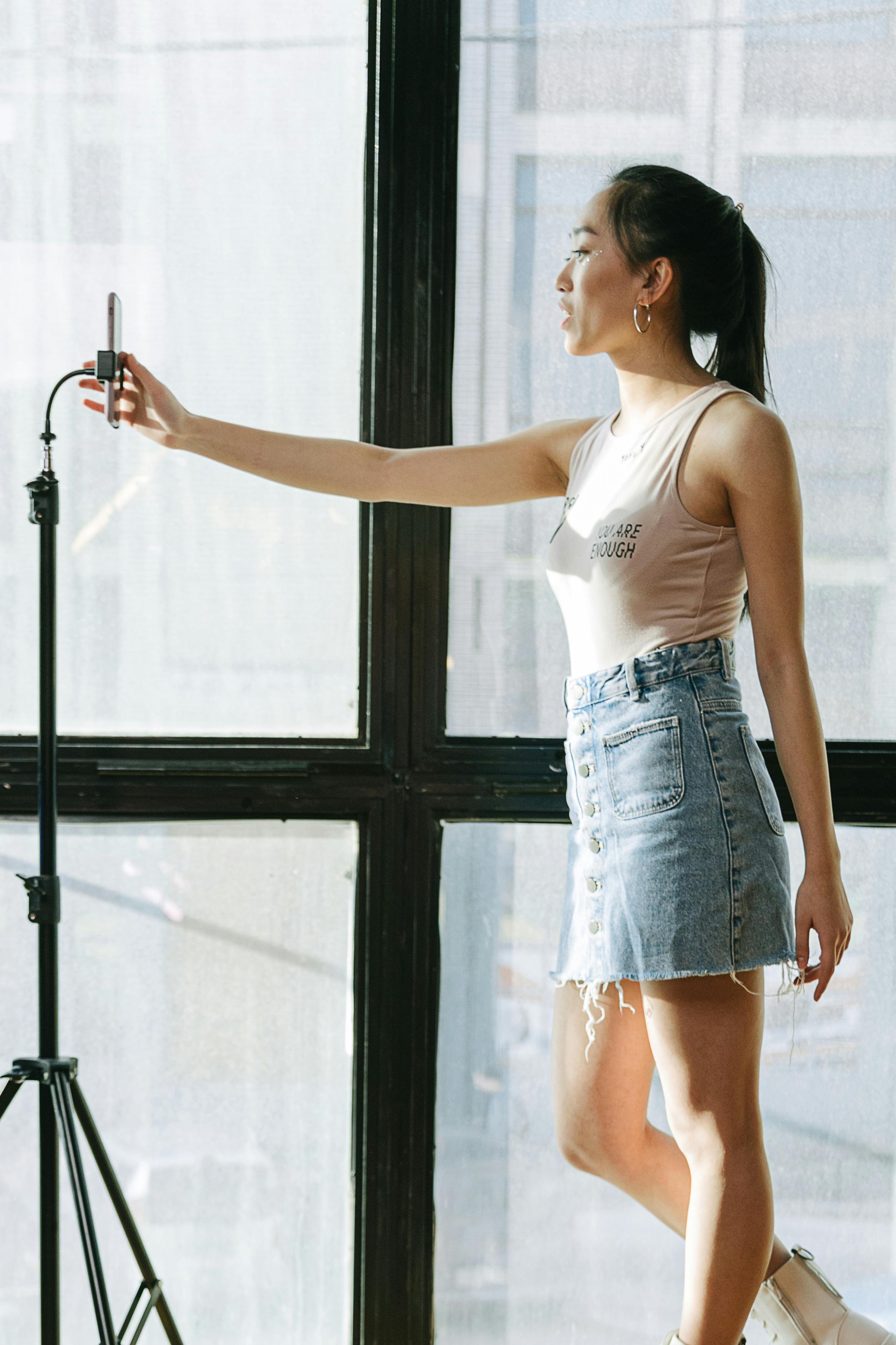 woman in tank top taking a video of herself