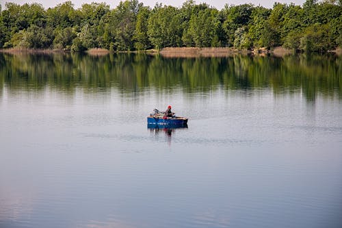 Man in a Blue Wooden Boat