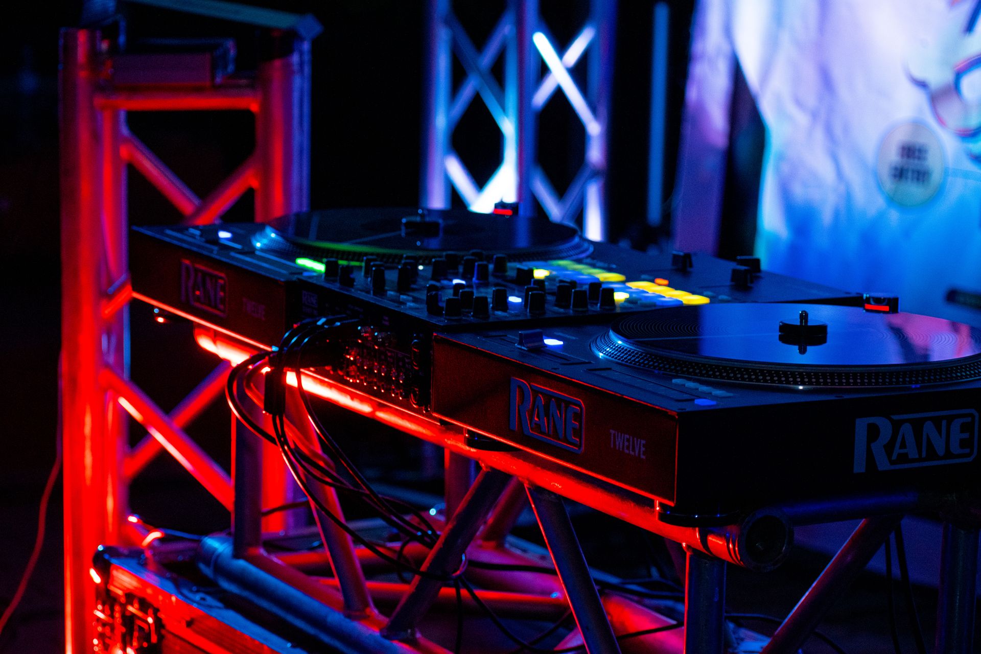 Colorful DJ setup featuring an illuminated turntable and mixer, perfect for music events.