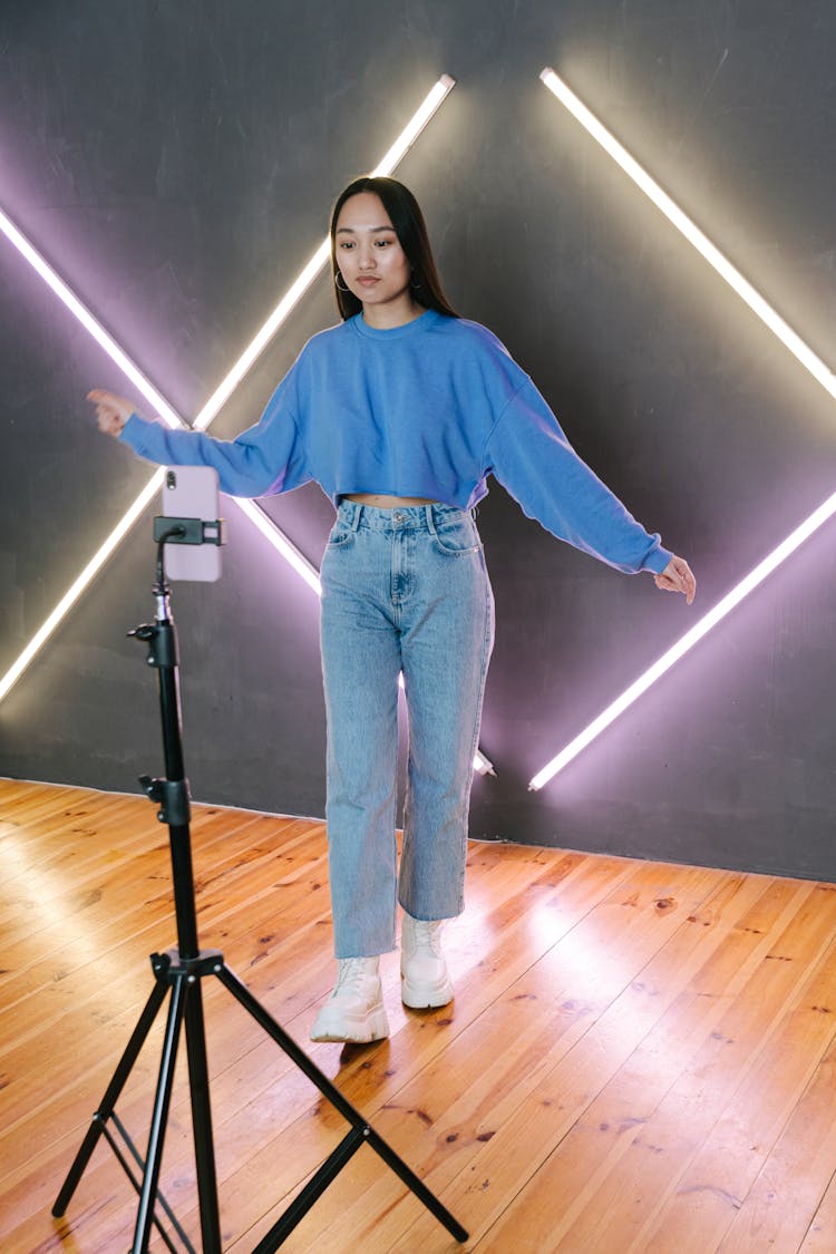 A Young Woman Filming While Dancing